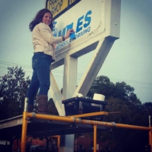 Joy installing Miles Driving School Landmark sign